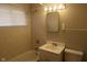Bright bathroom features tiled walls, a shower-tub combo, a mirror, and a modern vanity with a white sink at 4353 Evanston Ave, Indianapolis, IN 46205
