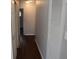 Hallway featuring hardwood floors and a white louvered closet door at 4353 Evanston Ave, Indianapolis, IN 46205