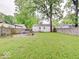 Spacious backyard with lush lawn, mature trees, and a patio, perfect for outdoor activities and relaxation at 4415 N Longworth Ave, Indianapolis, IN 46226