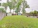 Large backyard with lush green grass, mature trees, and a fenced perimeter, creating a private outdoor oasis at 4415 N Longworth Ave, Indianapolis, IN 46226