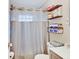 Compact bathroom with patterned shower curtain, floating shelves, and neutral tones for a clean, minimalist design at 4415 N Longworth Ave, Indianapolis, IN 46226