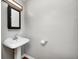 Cozy half bathroom featuring a vintage pedestal sink and a large wall mirror at 4621 E 17Th St, Indianapolis, IN 46218