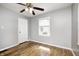 Empty bedroom has hardwood floors, a window, ceiling fan and neutral gray walls at 4621 E 17Th St, Indianapolis, IN 46218