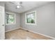 Bright bedroom with wood-look floors, light grey walls, and a ceiling fan at 4621 E 17Th St, Indianapolis, IN 46218