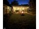 Inviting backyard with a screened-in patio, fire pit, and a dog running in the green grass at 4641 Ralston Ave, Indianapolis, IN 46205