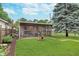 Lush backyard with a screened-in patio, fire pit, and well-maintained lawn at 4641 Ralston Ave, Indianapolis, IN 46205
