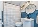 Bright bathroom featuring blue wainscoting and a round mirror at 4641 Ralston Ave, Indianapolis, IN 46205