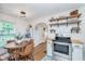 Charming kitchen features an eating area, white subway tile backsplash and open wooden shelves for storage at 4641 Ralston Ave, Indianapolis, IN 46205