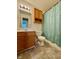 Well-lit bathroom with wooden cabinets, neutral tiling, and a shower with a patterned curtain at 509 Woodberry Dr, Danville, IN 46122