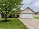 Charming home featuring an attached two-car garage, brick facade, manicured lawn and mature shade tree at 509 Woodberry Dr, Danville, IN 46122