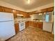 Bright kitchen with white appliances, wood cabinets, and neutral flooring at 509 Woodberry Dr, Danville, IN 46122