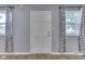 Bright entryway with white door, gray walls, light-colored flooring and window with curtains at 521 Elmhurst Pl, Whiteland, IN 46184