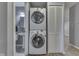 This well-lit laundry space features a stacked washer and dryer and built in shelving at 521 Elmhurst Pl, Whiteland, IN 46184