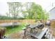 Inviting backyard featuring a wooden deck with picnic table, trampoline, and string lights for outdoor gatherings at 5374 John Quincy Adams Ct, Plainfield, IN 46168
