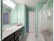 Bright bathroom featuring blue-green walls, a long vanity, and shower/tub combo with white shower curtain at 5374 John Quincy Adams Ct, Plainfield, IN 46168