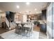 Open-concept dining area featuring a modern table, hardwood floors, and seamless flow to the kitchen at 5374 John Quincy Adams Ct, Plainfield, IN 46168