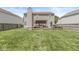 The home's sprawling backyard featuring a covered patio, lush grass, and privacy fencing at 5671 Glass Chimney Ln, Indianapolis, IN 46235