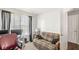 A bedroom featuring a cozy futon and a window with patterned curtains for natural light at 5671 Glass Chimney Ln, Indianapolis, IN 46235