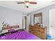 Comfortable bedroom with a ceiling fan, neutral walls, and a stylish wooden dresser at 5671 Glass Chimney Ln, Indianapolis, IN 46235