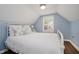 Bedroom boasts light blue walls, shuttered windows, and a white metal bed frame at 60 E Poplar St, Zionsville, IN 46077