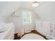 Bedroom features patterned wallpaper, hardwood floors, a changing table and a baby's crib at 60 E Poplar St, Zionsville, IN 46077