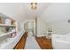 Bonus room features a light gray rug on hardwood floors and built in bookshelves and storage at 60 E Poplar St, Zionsville, IN 46077