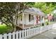 Charming home featuring a covered porch with swing, white picket fence, and American flag at 60 E Poplar St, Zionsville, IN 46077