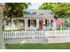 Charming home featuring a covered porch with swing, white picket fence, and American flag at 60 E Poplar St, Zionsville, IN 46077