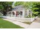 Charming home featuring a covered porch with swing, white picket fence, and American flag at 60 E Poplar St, Zionsville, IN 46077