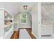 Hallway features hardwood floors, a built in bookshelf, and an entrance to a bathroom with patterned wallpaper at 60 E Poplar St, Zionsville, IN 46077