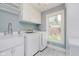 Modern laundry room with patterned floors, front load machines, and overhead cabinets at 60 E Poplar St, Zionsville, IN 46077