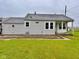 Quaint single-story home with a well-maintained lawn and neutral-colored siding under an overcast sky at 613 Anderson Rd, Anderson, IN 46017