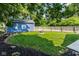 Landscaped backyard featuring a blue shed, wooden fence, firepit, and well-maintained lawn at 6264 Central Ave, Indianapolis, IN 46220