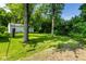 Spacious backyard with lush green lawn and mature trees, offering a serene outdoor space at 6264 Central Ave, Indianapolis, IN 46220