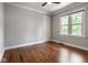 A simple bedroom with wood floors, a window, gray walls, and white trim at 6264 Central Ave, Indianapolis, IN 46220