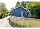 Blue brick home with fenced yard and steps to back door and long driveway at 6264 Central Ave, Indianapolis, IN 46220