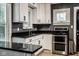 Modern kitchen with white cabinets, stainless steel appliances, and dark granite countertops at 6264 Central Ave, Indianapolis, IN 46220