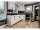 Bright kitchen with white cabinets, stainless steel appliances, and dark granite countertops at 6264 Central Ave, Indianapolis, IN 46220