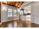 Open living room with hardwood floors and a partial view of the modern kitchen at 6264 Central Ave, Indianapolis, IN 46220