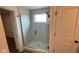 Modern bathroom featuring a glass-enclosed shower with tile surround and a window for natural light at 6338 Rippling Rock Dr, Plainfield, IN 46168