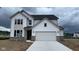 New two-story home featuring a two-car garage, brick accents, and a modern design under a cloudy sky at 6338 Rippling Rock Dr, Plainfield, IN 46168