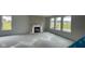 Spacious living room with large windows overlooking a pond and fireplace with white mantel at 6338 Rippling Rock Dr, Plainfield, IN 46168
