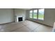 Spacious living room featuring a fireplace and large windows with a view of the backyard at 6338 Rippling Rock Dr, Plainfield, IN 46168