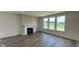 Bright living room featuring a fireplace, hardwood floors, and large windows with picturesque lake views at 6338 Rippling Rock Dr, Plainfield, IN 46168