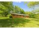 View of brick home from backyard, with mature trees and green grass at 6498 N County Road 475 E, Pittsboro, IN 46167
