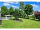 Spacious backyard with green grass, mature trees, and a wood deck at 7061 Blankenship Ave, Indianapolis, IN 46217