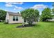 View of the backyard showcasing a well-maintained lawn, mature trees, and a wooden deck at 7061 Blankenship Ave, Indianapolis, IN 46217