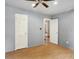 Bedroom with wood flooring, ceiling fan, and two doors with white trim at 7061 Blankenship Ave, Indianapolis, IN 46217