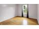 A sunlit bedroom with gray walls, wood floors, and a large window showcasing the exterior at 7061 Blankenship Ave, Indianapolis, IN 46217