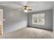 A spacious bedroom with carpet, neutral walls, a ceiling fan, and natural light from the window at 7061 Blankenship Ave, Indianapolis, IN 46217